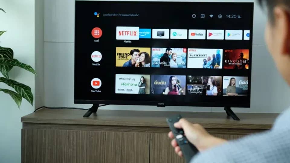 Person pointing a remote at a smart TV showing streaming apps