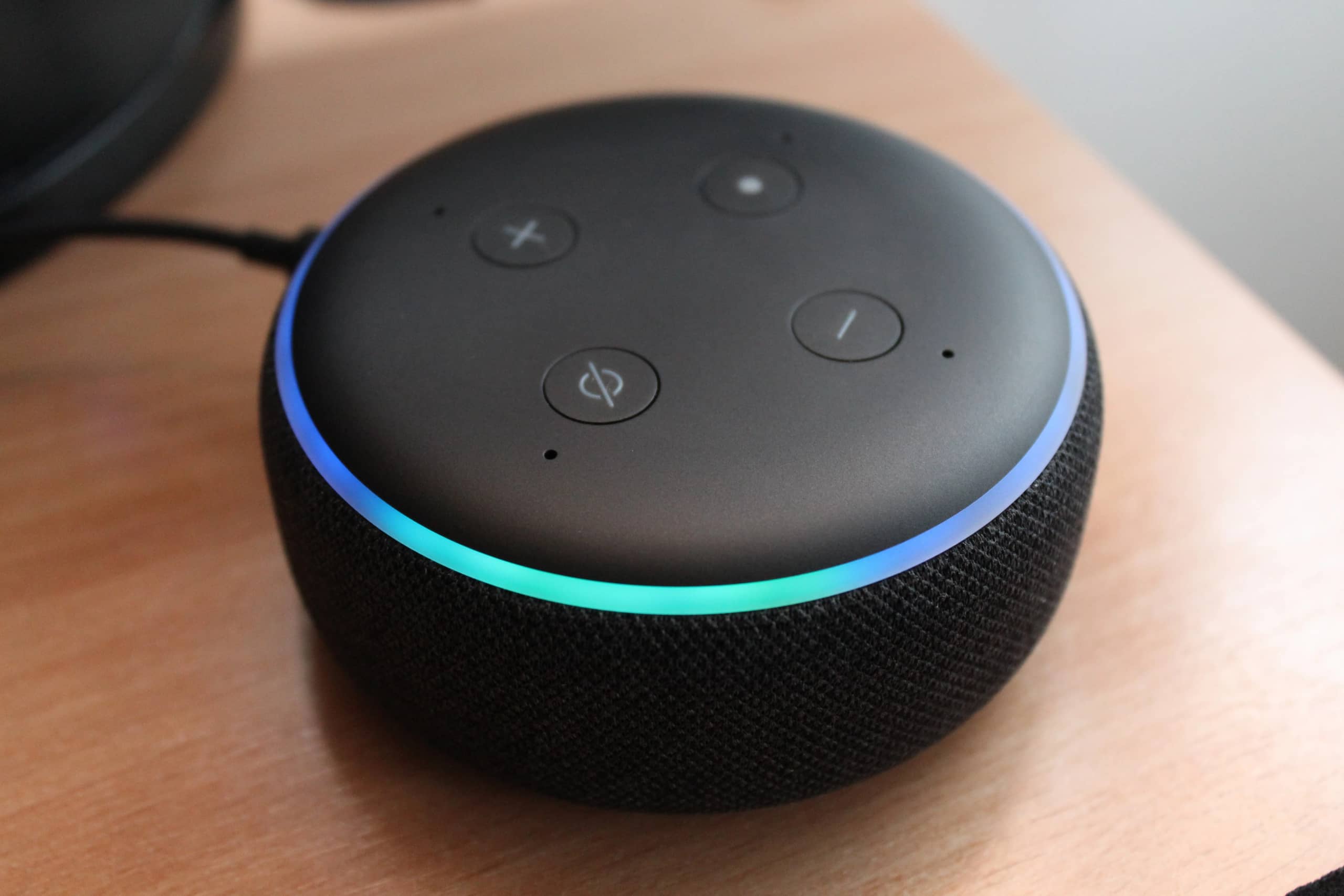 Smart speaker on a desk next to a laptop