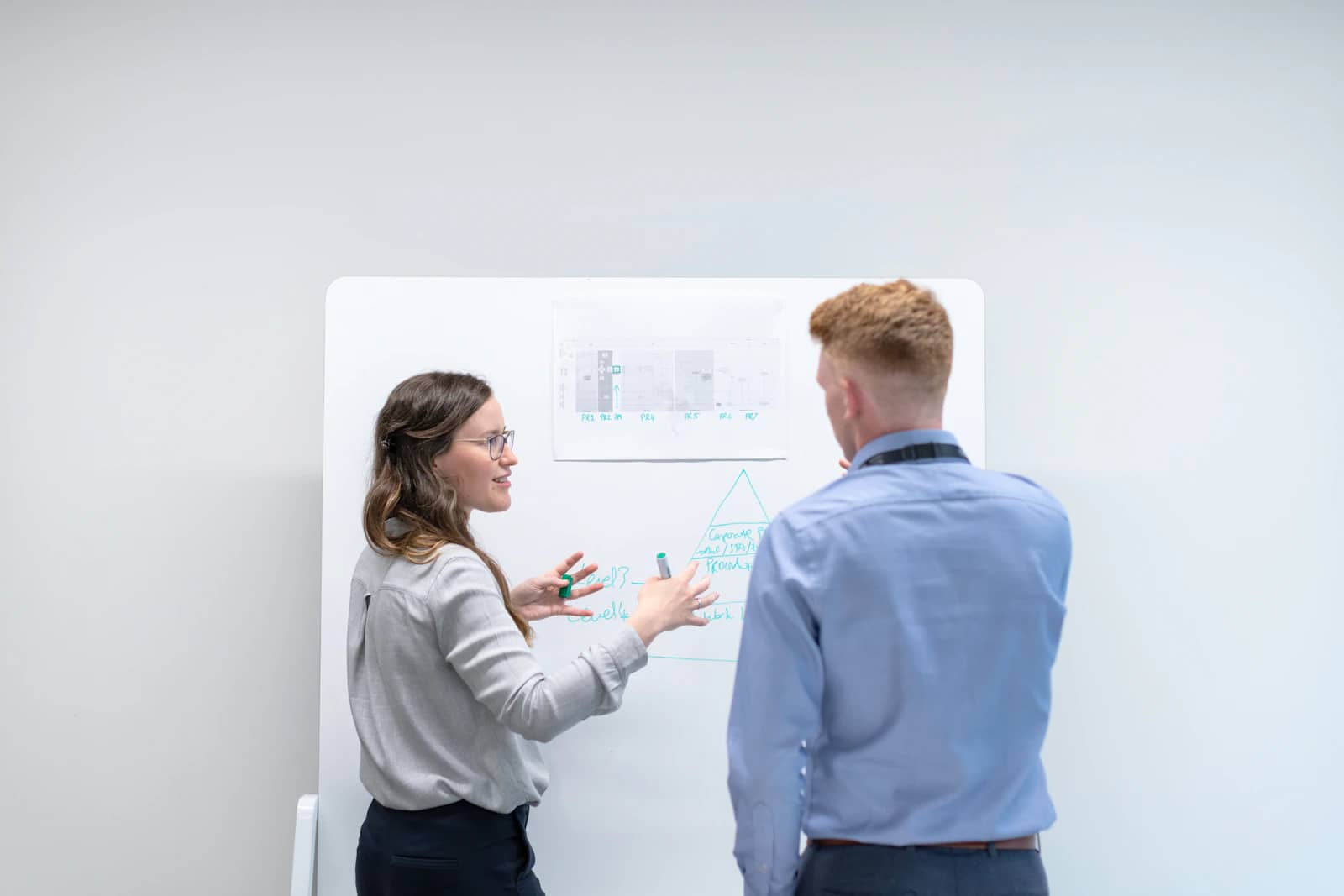 Colleagues discussing a brief at a whiteboard