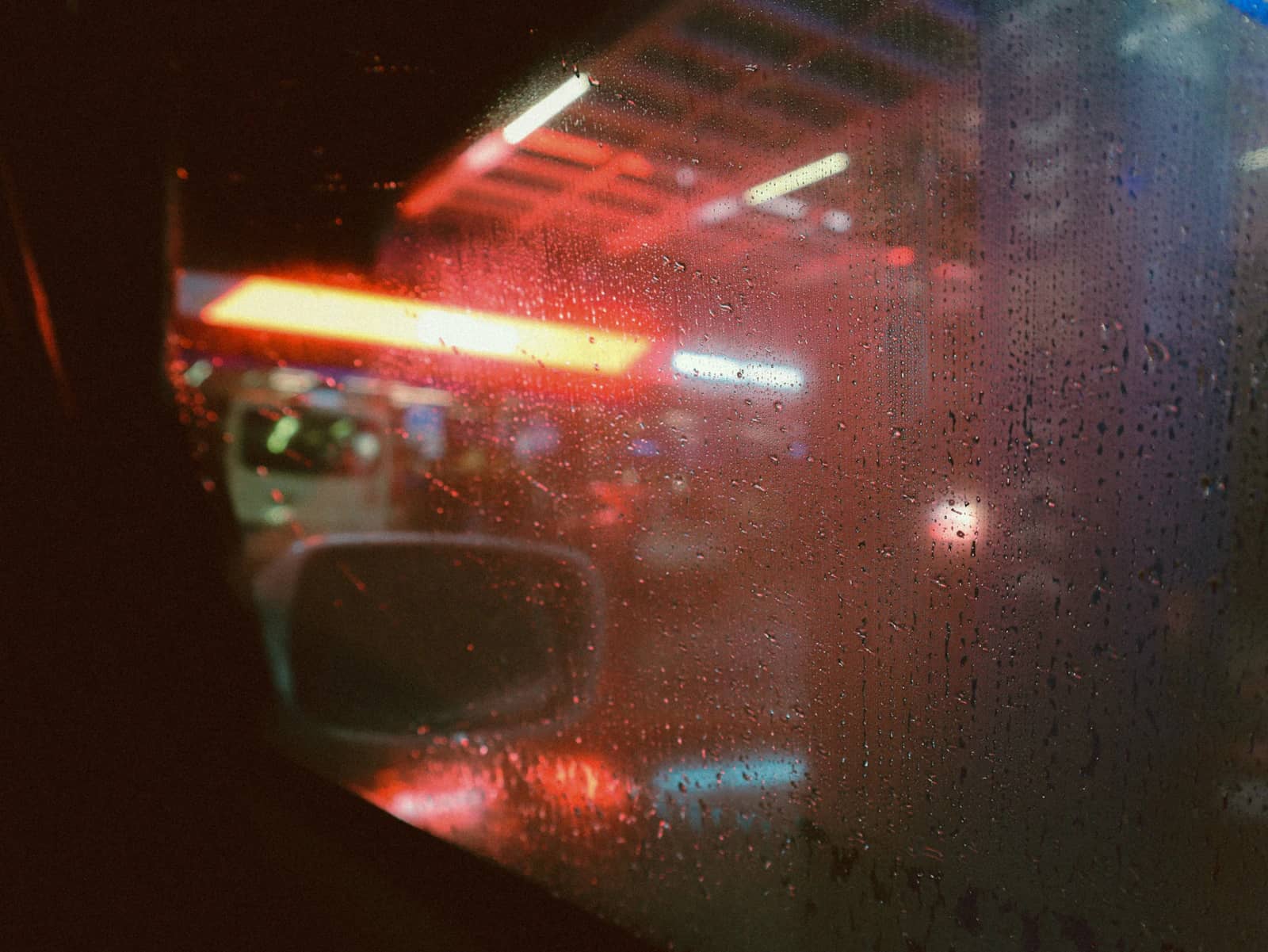 Condensation on a window with neon light behind